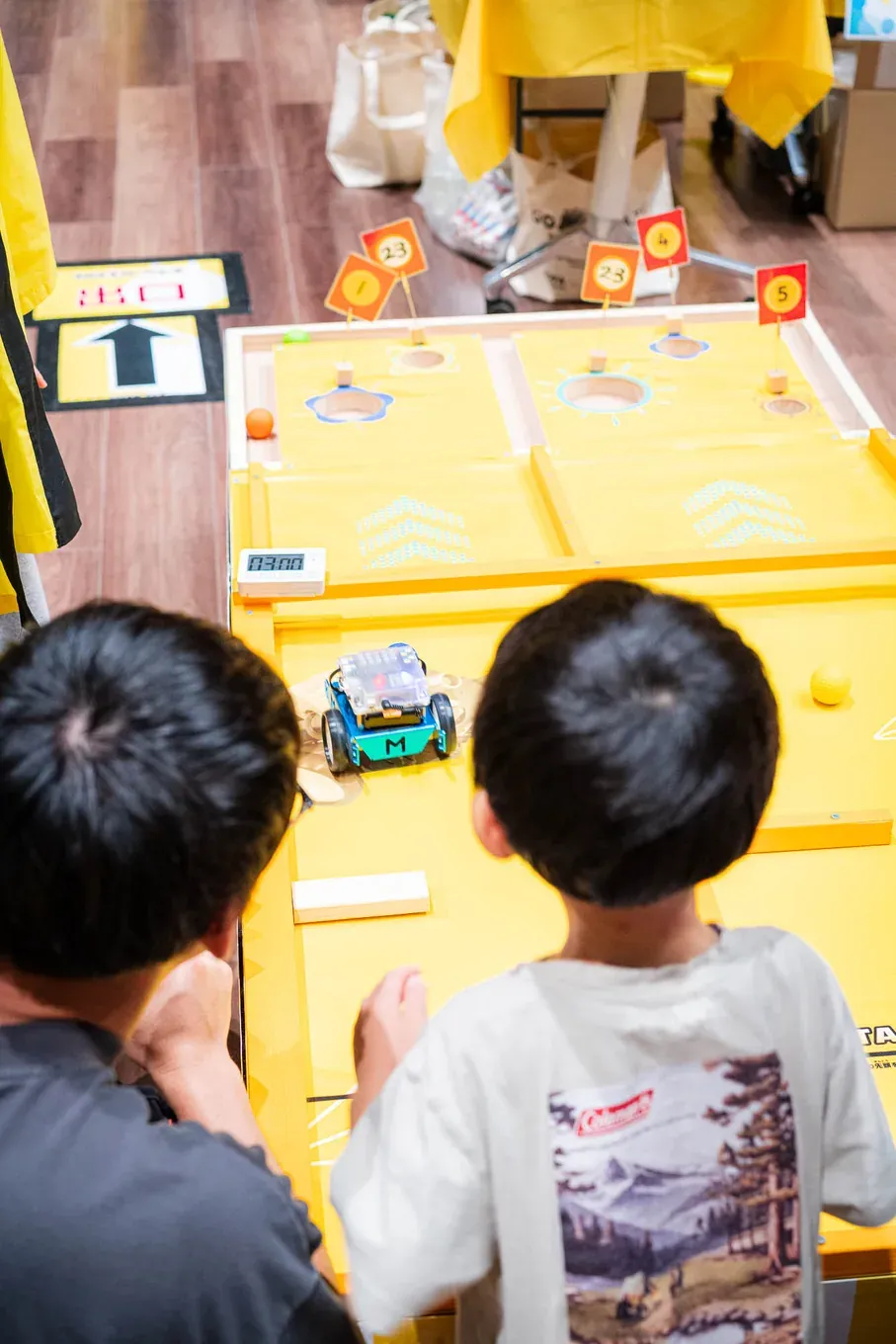 ロボット射的のブースで的をねらう2人の子ども
